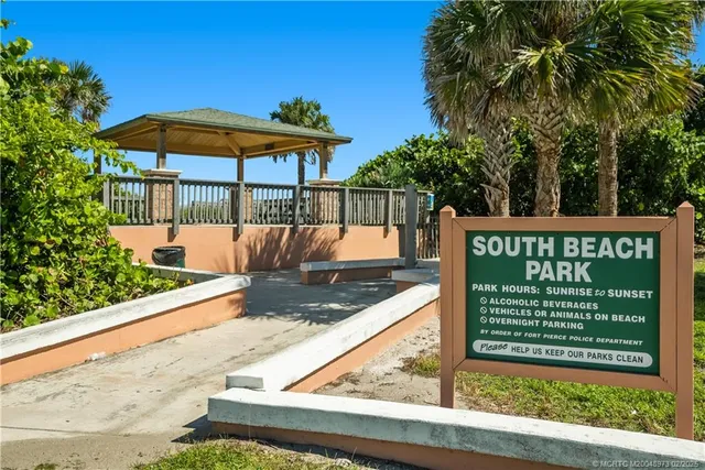 a view of multiple houses with a yard and palm trees
