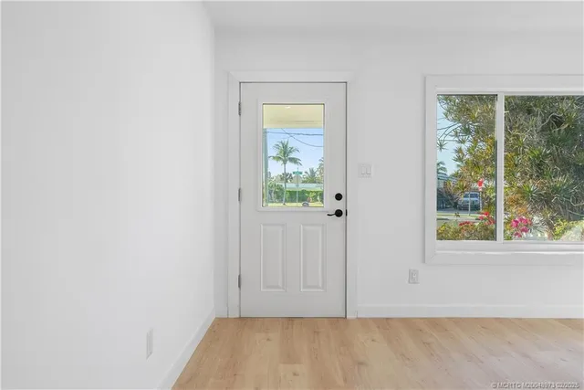 an empty room with a window and doors