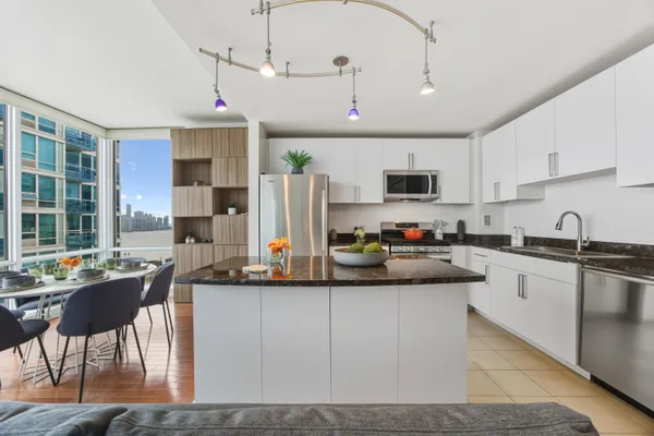 a kitchen with stainless steel appliances granite countertop a sink a stove and a refrigerator