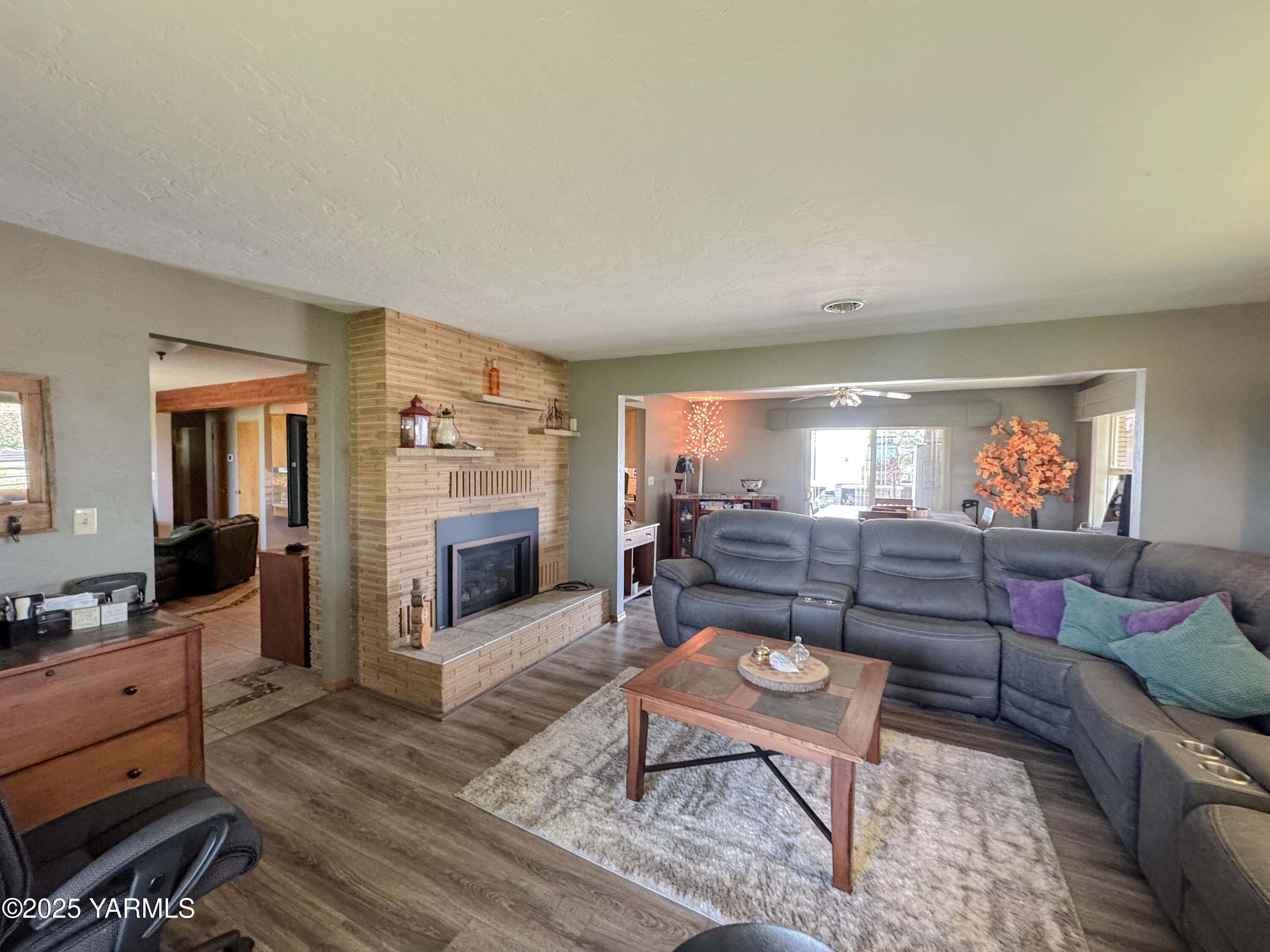 1450 Scoon Road Sunnyside, WA 98944 - Photo 4 of 33 a living room with furniture a fireplace and a flat screen tv