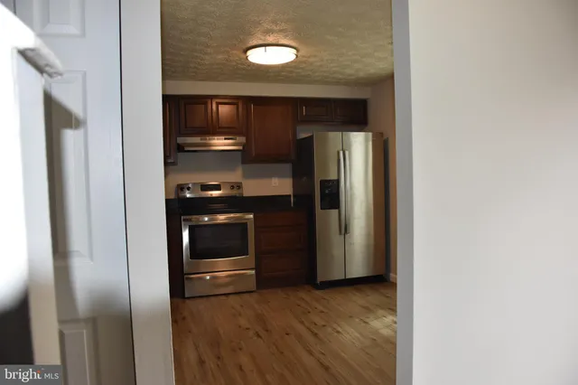 a view of a kitchen from a hallway