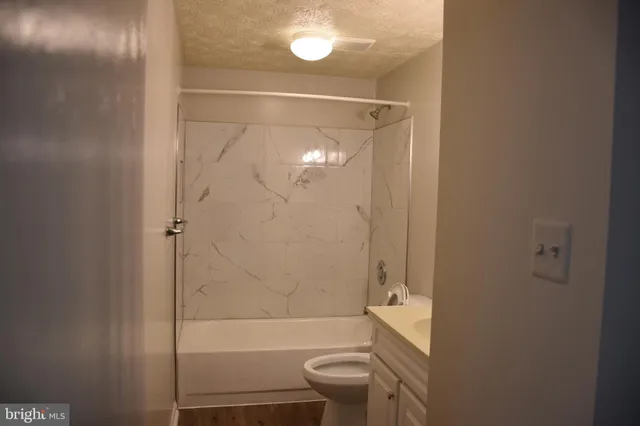 a bathroom with a granite countertop bathtub toilet and sink
