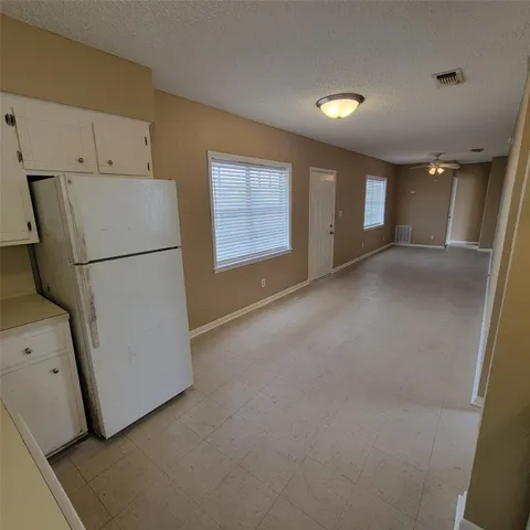 a view of a kitchen with refrigerator and cabinet
