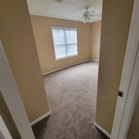 an empty room with windows and fan