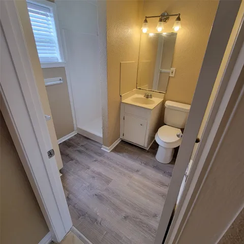 a bathroom with a sink a toilet a mirror and shower