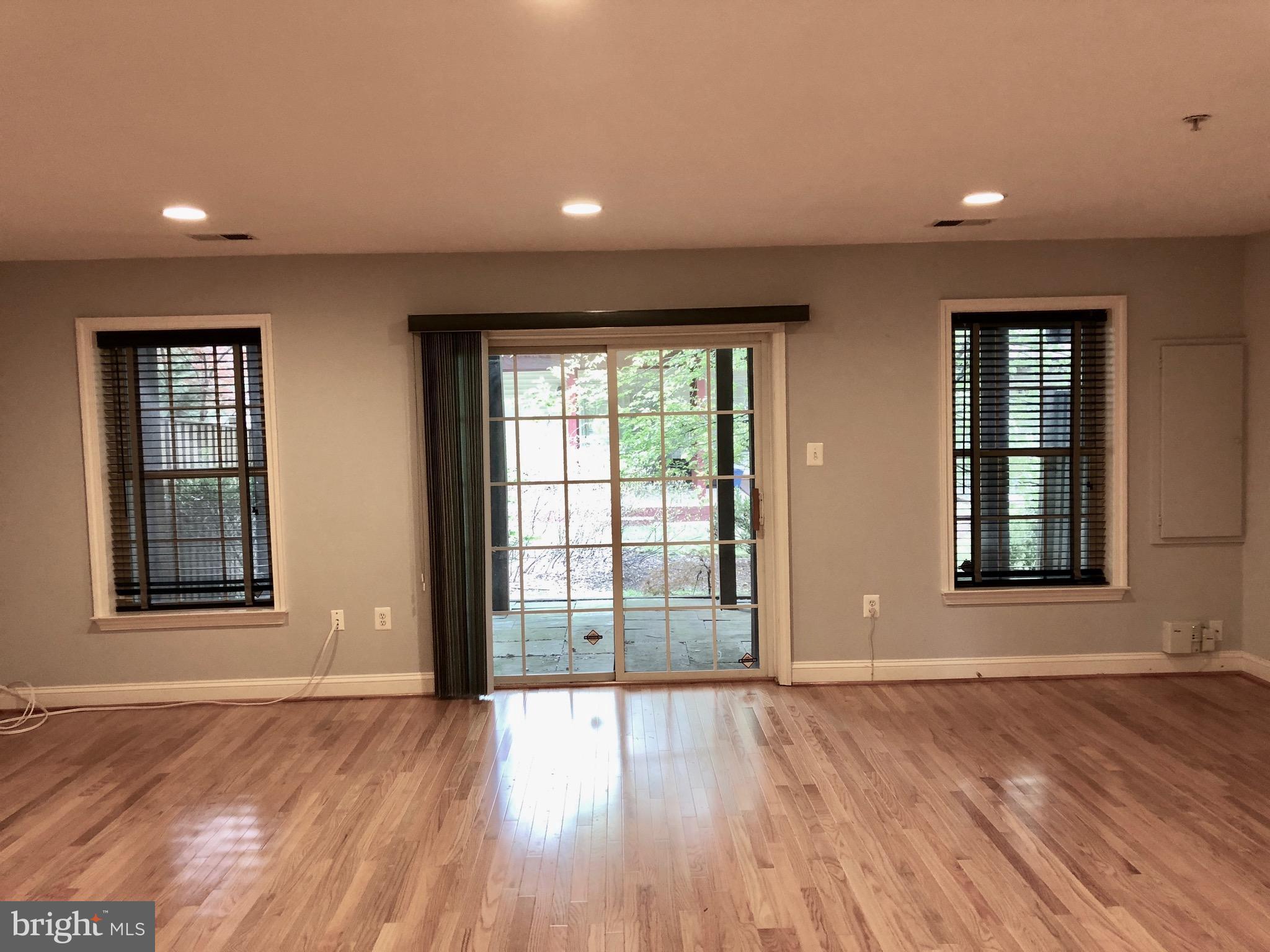 6402 Spring View Place Rockville, MD 20852 - Photo 14 of 25 an empty room with wooden floor and windows
