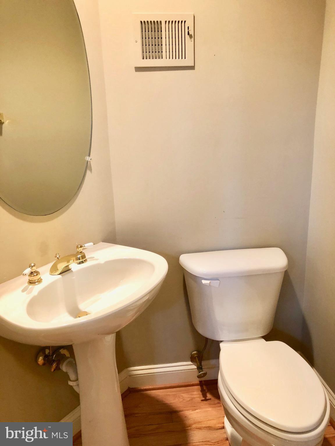 6402 Spring View Place Rockville, MD 20852 - Photo 16 of 25 a bathroom with a toilet a sink and a mirror