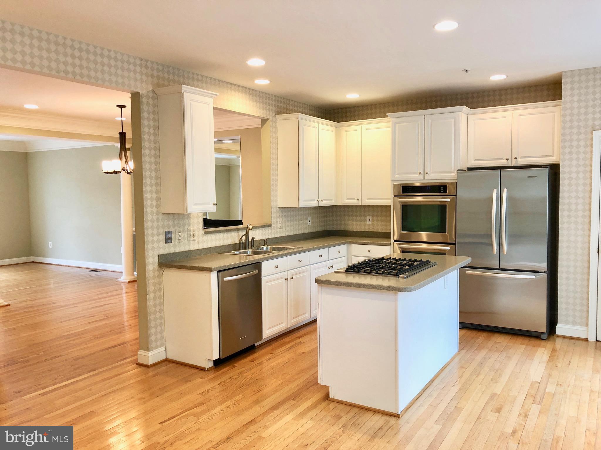 6402 Spring View Place Rockville, MD 20852 - Photo 8 of 25 a kitchen with granite countertop a stove top oven and refrigerator