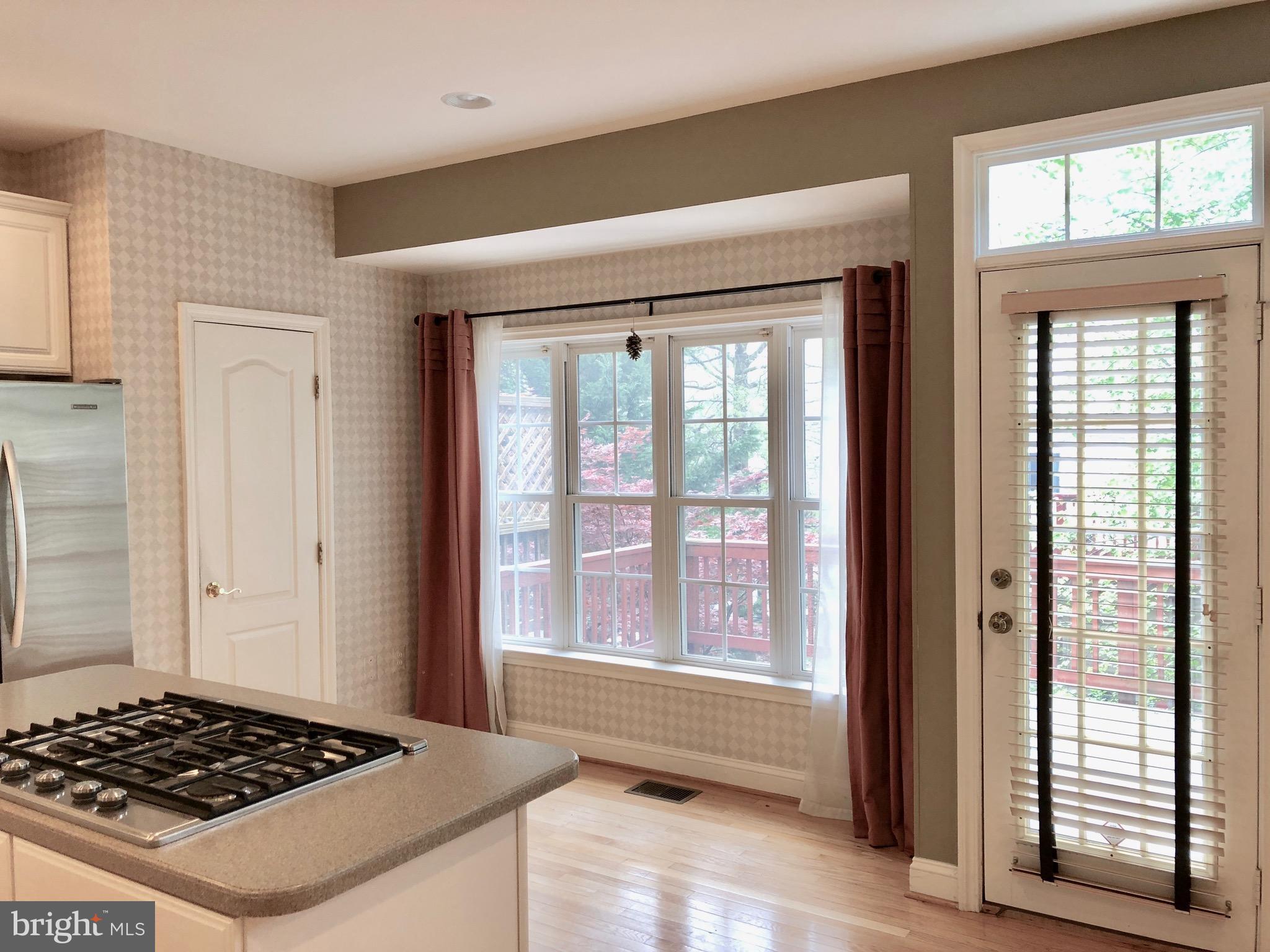 6402 Spring View Place Rockville, MD 20852 - Photo 9 of 25 a view of kitchen island with a stove and wooden floor