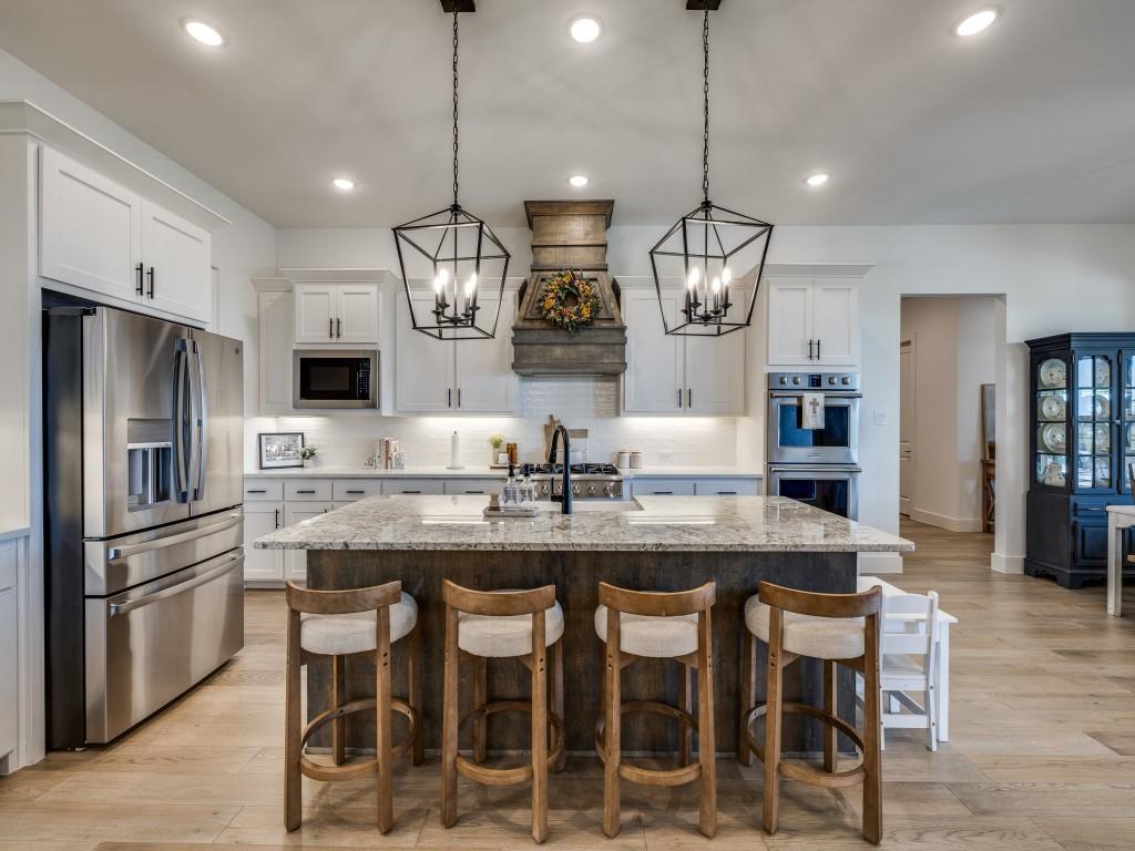 1956 Jc Maples Road Gunter, TX 75058 - Photo 11 of 38 a kitchen with granite countertop stainless steel appliances a table and chairs