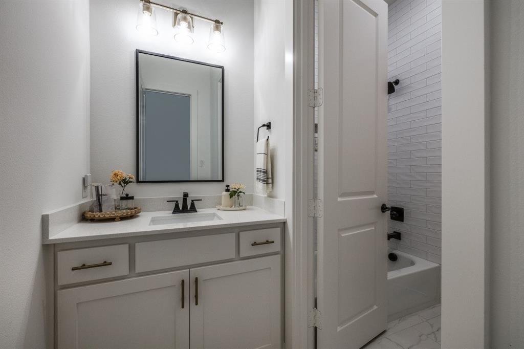 1956 Jc Maples Road Gunter, TX 75058 - Photo 27 of 38 a bathroom with a sink vanity and mirror