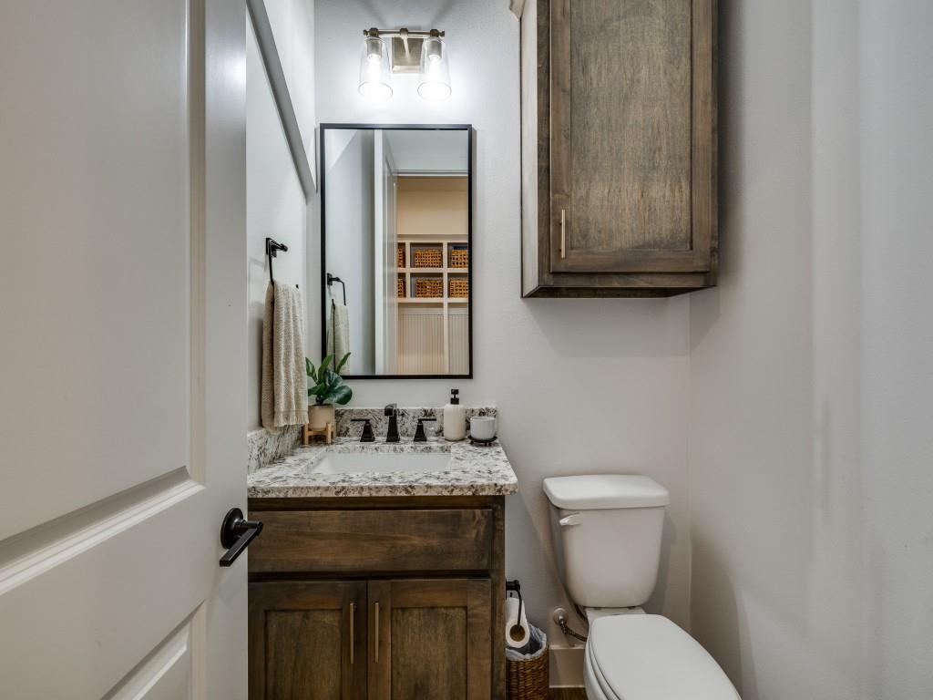 1956 Jc Maples Road Gunter, TX 75058 - Photo 32 of 38 a bathroom with a granite countertop toilet sink and mirror
