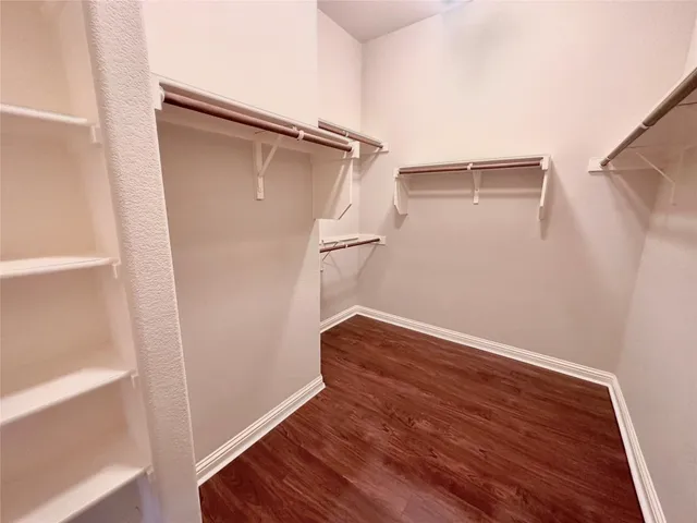 a view of walk in closet with empty racks