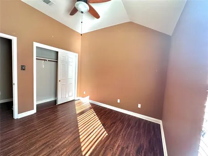 a view of an empty room with wooden floor