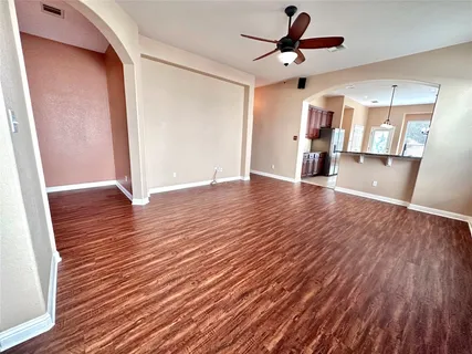 a view of an empty room with window and wooden floor