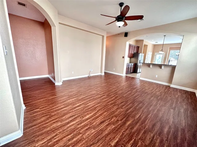 a view of an empty room with window and wooden floor