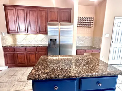 a kitchen with granite countertop wooden cabinets and granite counter tops