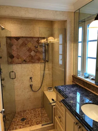a bathroom with a granite countertop shower and a sink
