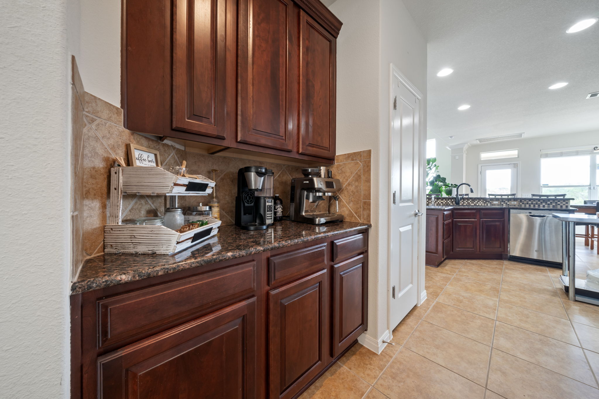 1581 Grassy Field Road Austin, TX 78737 - Photo 13 of 37 Rich wood cabinetry paired with stone countertops creates a functional Butler's pantry area.