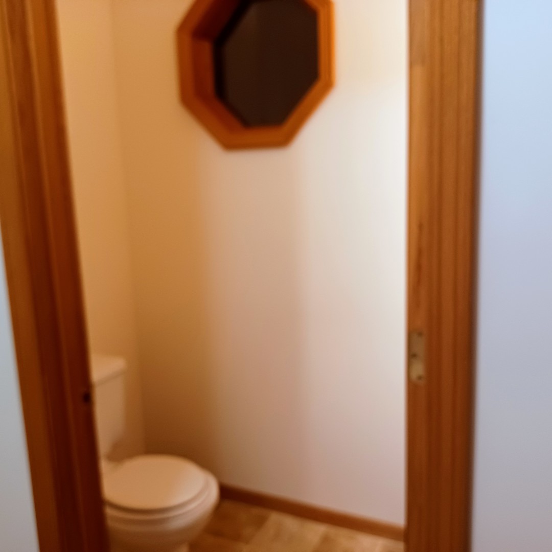 26 Vermont Avenue Bloomington, IL 61701 - Photo 5 of 15 a white toilet sitting next to a wooden vanity