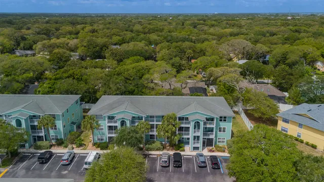 an aerial view of residential houses with outdoor space and trees