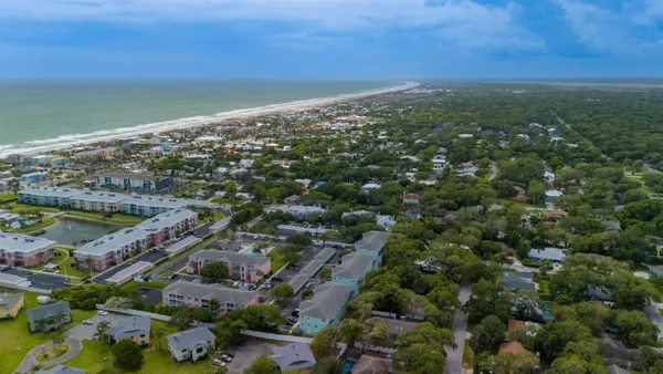 an aerial view of residential houses with outdoor space and trees