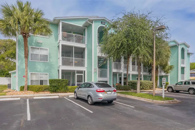 a patio with table and chairs and potted plants