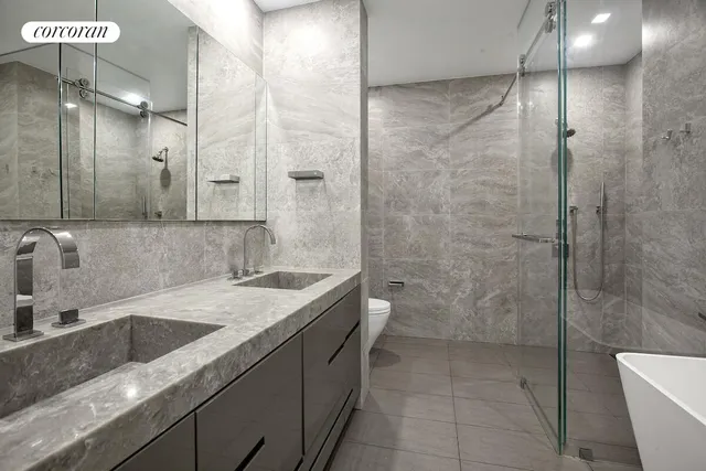 a bathroom with a granite countertop sink a toilet and shower