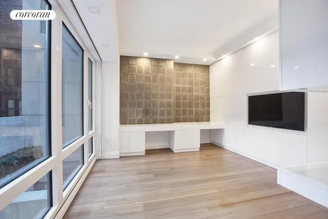 a view of a living room with a flat screen tv and floor to ceiling window