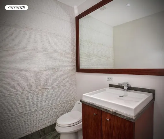 a bathroom with a sink a toilet and mirror