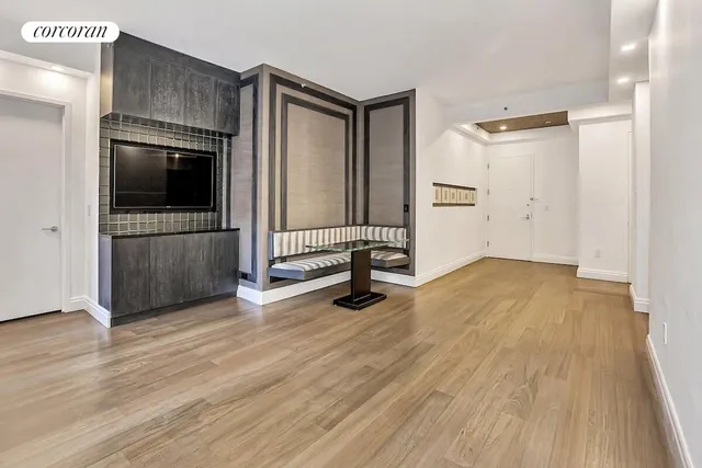 a view of a livingroom with wooden floor and a cabinet