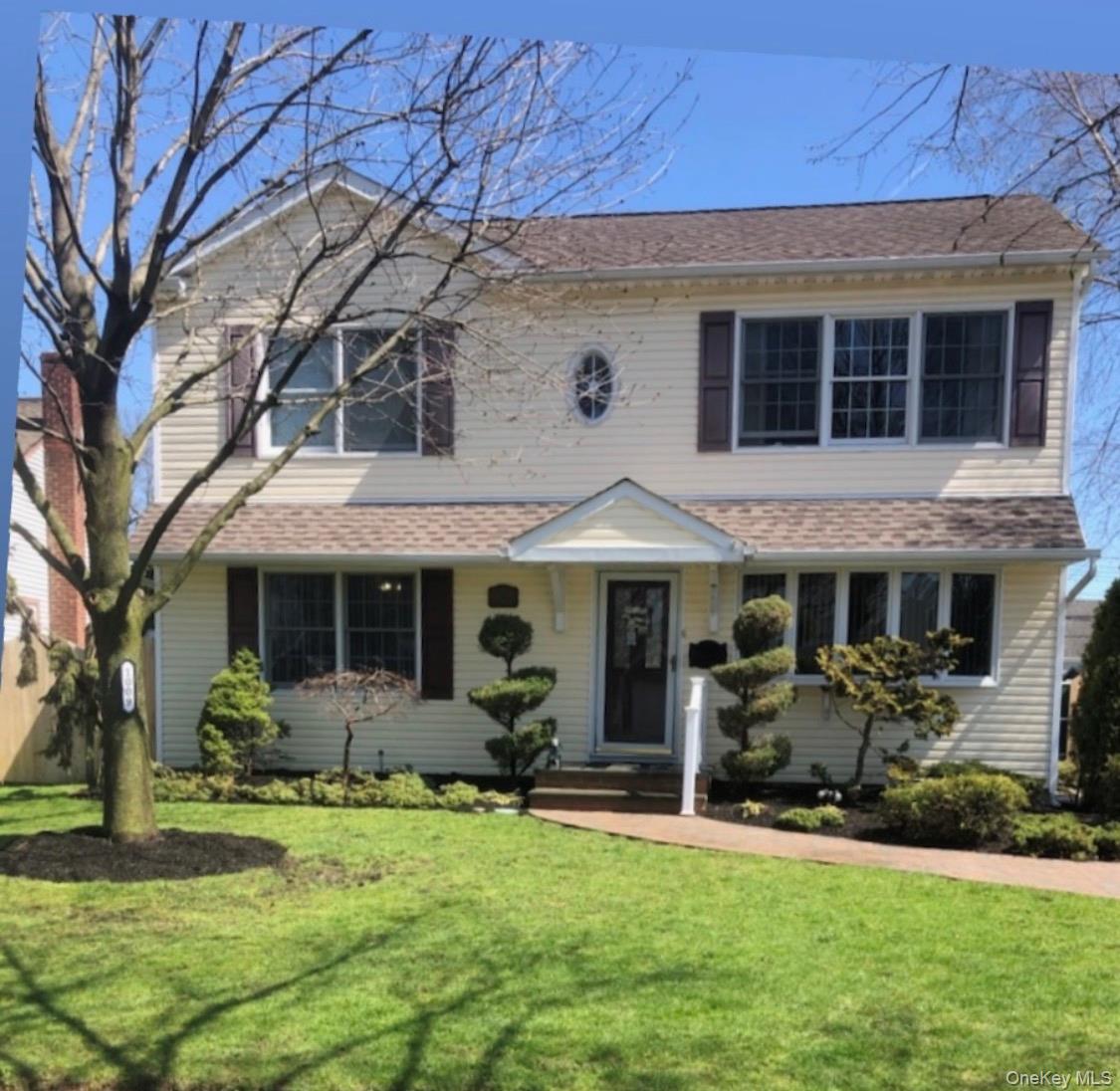 a front view of a house with a yard and potted plants