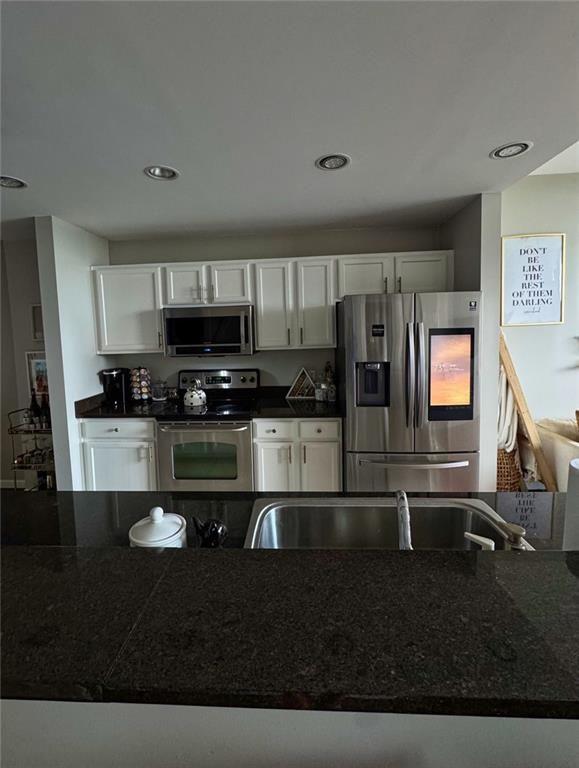 3040 Peachtree Road Northwest, Unit 707 Atlanta, GA 30305 - Photo 10 of 38 a kitchen with stainless steel appliances granite countertop a stove a sink and a microwave