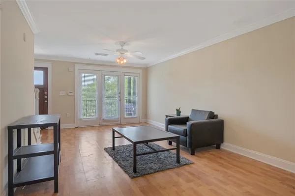 a living room with furniture a window and a potted plant