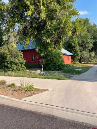 a view of backyard with a barn and large trees