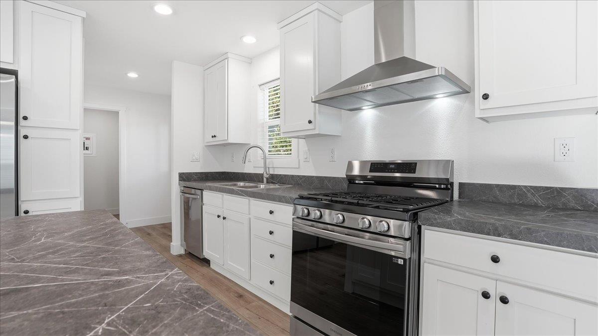 135 Ponderosa Way, Unit 14 Colfax, CA 95713 - Photo 14 of 37 a kitchen with stainless steel appliances granite countertop a stove a sink and a refrigerator
