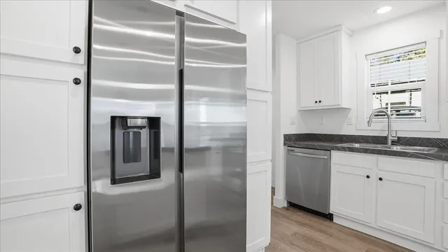 a kitchen with granite countertop stainless steel appliances a sink and cabinets