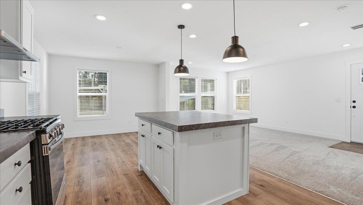 135 Ponderosa Way, Unit 14 Colfax, CA 95713 - Photo 16 of 37 a kitchen with granite countertop a stove and a wooden floor
