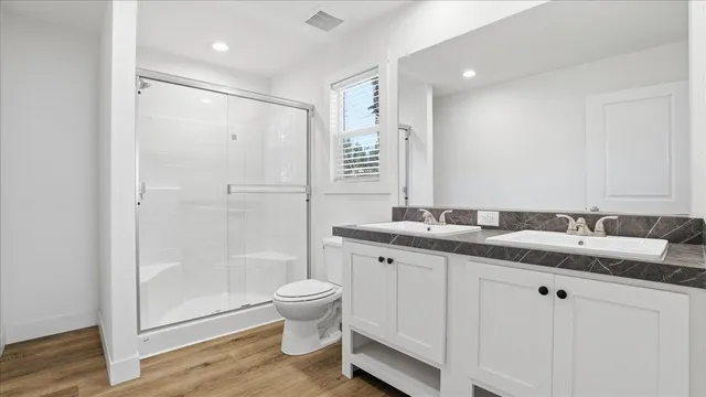 a bathroom with a granite countertop sink toilet and shower