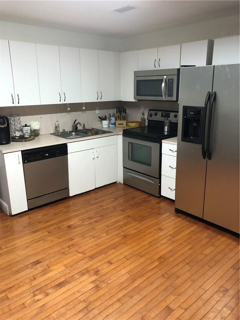 14309 Southwest 96th Street, Unit 505 Miami, FL 33186 - Photo 4 of 11 a kitchen with granite countertop a stove a sink and a refrigerator