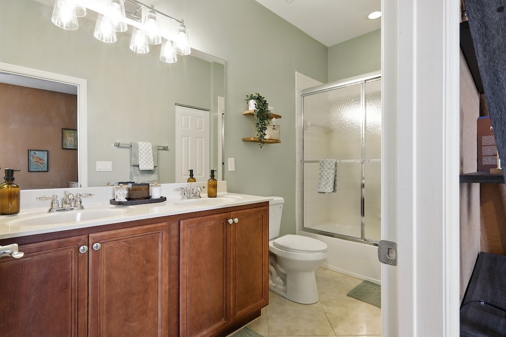 263 Provence Place Vero Beach, FL 32960 - Photo 11 of 33 a bathroom with a granite countertop sink a toilet and a mirror