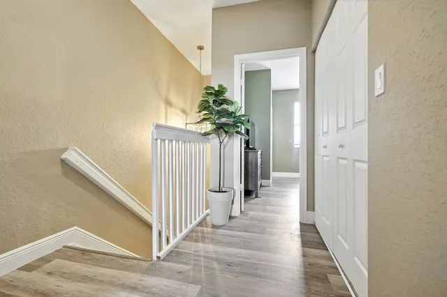 a view of a hallway with wooden floor and staircase