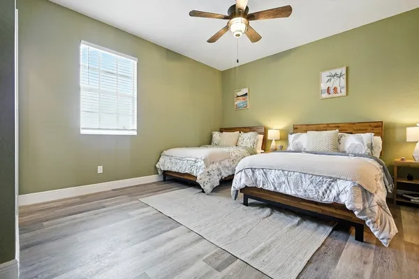 a spacious bedroom with a bed and wooden floor