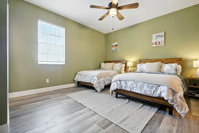 a spacious bedroom with a bed and wooden floor