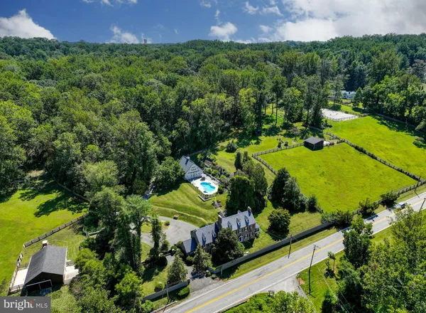 an aerial view of a house with a yard and lake