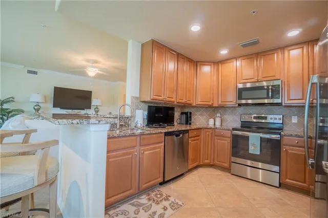 a kitchen with stainless steel appliances granite countertop a refrigerator a stove top oven a sink and dishwasher