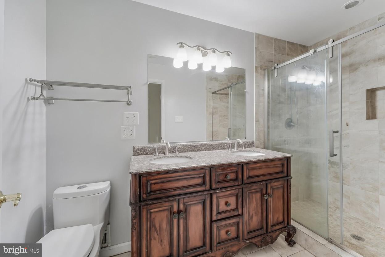 11621 Sourwood Lane Reston, VA 20191 - Photo 14 of 26 a spacious bathroom with a granite countertop shower sink vanity and toilet