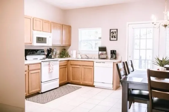a kitchen with a stove a sink a dining table and chairs
