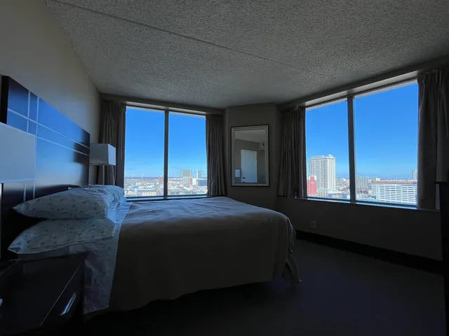 a bedroom with a bed next to a window