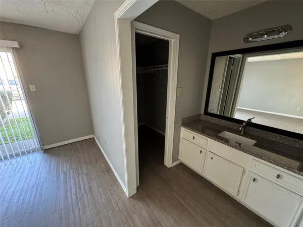 a view of bathroom with a sink mirror and window